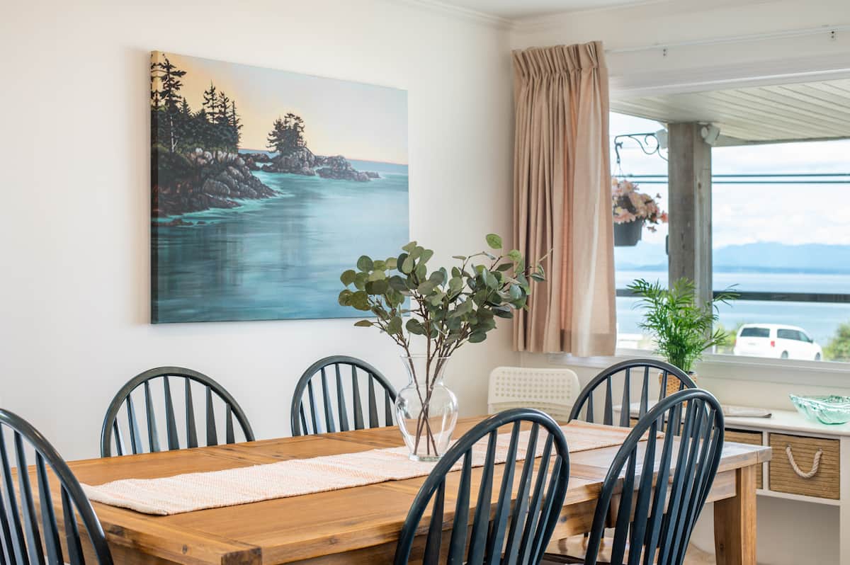 Dining area with ocean painting and ocean view